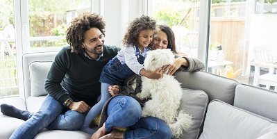 Mom, dad, daughter and dog play in living room